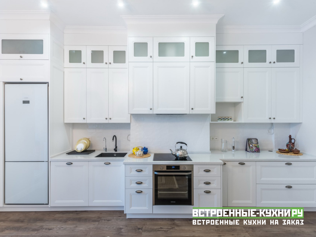 Белая прямая кухня со встроенным холодильником с антресолями